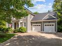 Side view of a well-maintained house with a spacious two-car garage and a neatly landscaped yard at 204 Rossburn Way, Chapel Hill, NC 27516