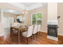 Elegant dining room showcasing a fireplace, tray ceiling, chandelier, and hardwood floors, next to the kitchen at 209 Mccarthy Dr, Clayton, NC 27527