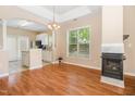 Dining room area with view of kitchen featuring hardwood floors, a fireplace, and ample natural light at 209 Mccarthy Dr, Clayton, NC 27527