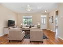 Bright living room featuring hardwood floors, large windows, a ceiling fan, and neutral wall paint at 209 Mccarthy Dr, Clayton, NC 27527