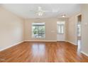 Bright living room featuring hardwood floors, a ceiling fan, and a large window allowing for ample natural light at 209 Mccarthy Dr, Clayton, NC 27527