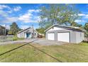 Property includes a home with stone chimney and a two-car garage with white doors on a well-maintained lawn at 2501 Ferrell Rd, Durham, NC 27704