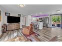Open-concept living space featuring a kitchen, entertainment area with a TV, and stylish furniture with gray vinyl floors at 2501 Ferrell Rd, Durham, NC 27704