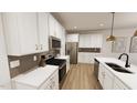 Bright kitchen featuring stainless steel appliances, white cabinets, and tile backsplash at 2917 Alyssa Ct, Knightdale, NC 27604