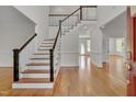 Bright foyer with hardwood floors, staircase, and views into adjacent rooms at 303 Crooked Meadow Ln, Hillsborough, NC 27278
