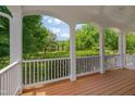 Covered porch view of green lawn with mature trees and landscaping at 303 Crooked Meadow Ln, Hillsborough, NC 27278