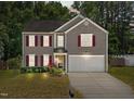 Charming two-story home boasts red shutters, a well-maintained lawn, and an attached two car garage at 3069 Buttonwood Ln, Clayton, NC 27520