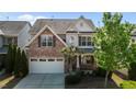 Charming home showcasing manicured lawn, brick accents, and a two-car garage at 309 Windy Peak Loop, Cary, NC 27519