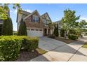 Desirable home featuring lush landscaping, brick accents, and an attached garage at 309 Windy Peak Loop, Cary, NC 27519