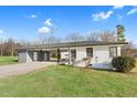 Exterior view of a white brick home with a convenient carport and gray siding against a blue sky at 311 Nc 56, Louisburg, NC 27549