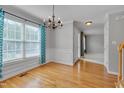 Bright dining room featuring hardwood floors, large window, and decorative chandelier at 3315 Swinford Ct, Raleigh, NC 27604
