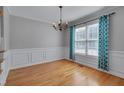 Elegant dining room showcasing hardwood floors, decorative chandelier, and large window at 3315 Swinford Ct, Raleigh, NC 27604