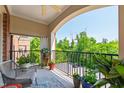 Open-air balcony with seating and views of surrounding trees and parking area at 340 Allister Dr # 201, Raleigh, NC 27609
