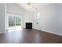 Bright living room with fireplace, wood floors, ceiling fan, and sliding glass door to backyard at 3601 Sugar Tree Pl, Durham, NC 27713