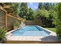 Sparkling pool with a serene waterfall feature, surrounded by lush landscaping at 3617 Carlow Ct, Raleigh, NC 27612