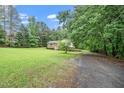 Inviting home surrounded by a lush green lawn and mature trees, featuring a charming brick and siding exterior at 4006 Daniel Rd, Durham, NC 27703