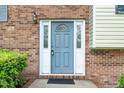 Close-up of the front door, showing the brick facade and decorative sidelights, with a gray painted door at 4006 Daniel Rd, Durham, NC 27703