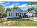 Street view of a charming single-story house with light-blue siding and a well-kept lawn and plantings at 407 Collier St, Smithfield, NC 27577