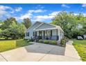 Angle view of a cozy house with beautiful lawn, a covered porch, and a concrete driveway at 407 Collier St, Smithfield, NC 27577