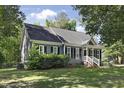 Landscaped front yard of a gray home with white trim, black shutters and a black roof at 413 Redpath Dr, Garner, NC 27529