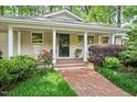 Inviting front porch with brick walkway, classic pillars, and decorative front door at 415 Forsyth St, Raleigh, NC 27609
