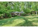 Well-maintained front yard featuring lush lawn, mature trees, and landscaped garden beds at 415 Forsyth St, Raleigh, NC 27609