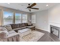 Cozy living room with a fireplace, ceiling fan, and large windows for natural light at 4613 Jersey Pine Dr, Rolesville, NC 27571