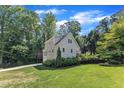 Home exterior with expansive lawn, showing side view and mature landscaping at 4900 North Hills Dr, Raleigh, NC 27612