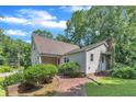 Home exterior featuring a welcoming side entrance with brick steps and mature landscaping at 4900 North Hills Dr, Raleigh, NC 27612