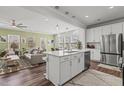 Open-concept kitchen with stainless appliances, island with barstool seating, and modern lighting at 5054 Kota St, Raleigh, NC 27610