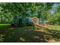 Quaint single-story home with lush greenery, carport, and inviting curb appeal at 5100 Yale Ct, Graham, NC 27253