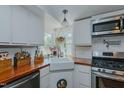 Bright kitchen features white cabinets, wood countertops, and stainless steel appliances at 5100 Yale Ct, Graham, NC 27253