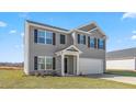 Two-story home with gray exterior, a two-car garage and a green lawn at 511 Lochalsh Dr, Gibsonville, NC 27249