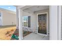Close-up of the front door and stone details of the covered front porch at 511 Lochalsh Dr, Gibsonville, NC 27249