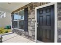 Close-up of the home's exterior showcasing a sleek black front door and stone facade at 521 Glenwyck Ct, Fuquay Varina, NC 27526