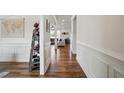 Elegant hallway features hardwood floors, white wainscoting, and views into the living area at 521 Glenwyck Ct, Fuquay Varina, NC 27526