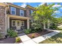 Charming two-story home featuring stone and siding accents, a welcoming front porch, and beautifully landscaped yard at 7304 Hasentree Club Dr, Wake Forest, NC 27587