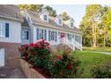 Charming home featuring a brick foundation, dormer windows, blue shutters and walkway up to the front door at 7405 Chickadee Ct, Sanford, NC 27332