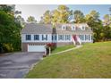 A two story traditional home featuring a two car garage, dormer windows, and manicured yard at 7405 Chickadee Ct, Sanford, NC 27332