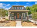 Inviting home featuring a charming front porch with brick accents, freshly landscaped yard and new sidewalk at 801 N Elm St, Durham, NC 27701
