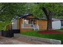 Charming home features a covered porch, wood siding, and a mature shade tree at 805 Camden Ave, Durham, NC 27701