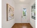 Bright entryway with hardwood floors, white walls, and a glass-paneled front door view of the neighborhood at 909 N Gregson St, Durham, NC 27701