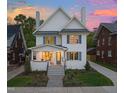 Stunning two-story white home with beautiful landscaping, blue shutters, and a welcoming front porch at 909 N Gregson St, Durham, NC 27701