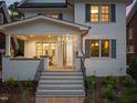 Charming front porch with stone flooring, white brick pillars, and an inviting entrance with a glass-paneled front door at 909 N Gregson St, Durham, NC 27701