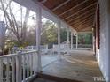 Expansive porch with white railings, offering a tranquil outdoor space with views of surrounding trees at 915 Phils Creek Rd, Chapel Hill, NC 27516