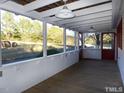 Relaxing screened porch with wood floors and lighting, providing serene views of the grassy backyard at 915 Phils Creek Rd, Chapel Hill, NC 27516