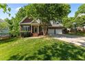 Charming brick home with a well-manicured lawn, mature trees, and two-car garage at 104 Crossway Ln, Holly Springs, NC 27540