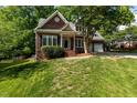 Traditional brick home with manicured lawn, mature trees, and a welcoming entrance at 104 Crossway Ln, Holly Springs, NC 27540