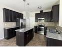 Stylish kitchen with stainless steel appliances, granite countertops, and dark cabinets at 105 Blue Bay Ln, Cameron, NC 28326