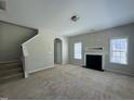 Spacious living room featuring neutral paint, plush carpet, a fireplace, and staircase at 105 Blue Bay Ln, Cameron, NC 28326